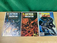 Three Batman vs Predator comics laid side by side showing full front covers