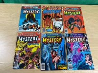 All six DC The House of Mystery comic books laid out on table showing covers