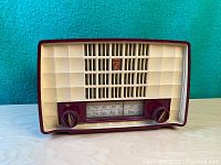 Full front view of vintage Philips radio showing entire front with tuning knobs, frequency dial, and speaker grille.