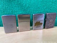 Four vintage Zippo lighters arranged side by side showing overall appearance and condition.