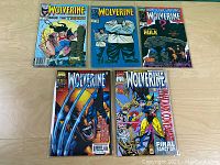 Five Wolverine comic books laid out flat showing front covers distinctly.
