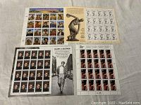 Five sheets of various vintage US postage stamps included in the lot, laid out flat showing a diverse assortment of themes.