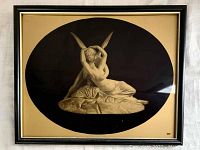 Front view of the framed print showing the artwork depicting two figures in an embrace with a black oval matte and gold background in an antique style frame.