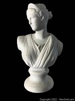Front left angled view of bisque ware bust showing detailed draped clothing and facial features against black background.