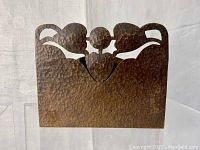 Front view of hammered copper letter or napkin holder showing decorative cut-out top and textured hammered surface.
