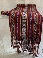 Rolled and draped wool shawl showing detailed pattern and fringe