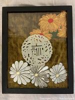 Front view of framed jade medallion with floral embroidery