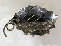 Front view of the antique silver leaf pin showing detailed veining and curled stem design.