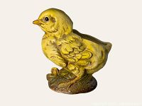 Front-side view of the yellow chick-shaped vase showing detailed feather textures and base