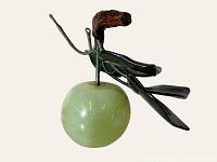 Front view of light green jade apple sculpture with metal stem and dark green metal leaves.