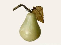Front view of jade pear showing shape, leaf and stem with visible glue repair on the side.