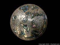 Front view of round Taxco sterling silver pin/pendant with Mayan design and colorful mother of pearl inlay on black background.