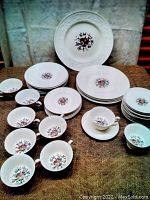 Full set showing plates of different sizes stacked and arranged with teacups and saucers.