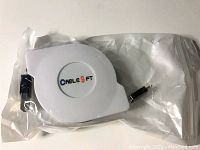 White retractable charging cable housing labeled 'CABLE 9 FT', packaged in plastic. Cable connectors visible: USB-C and Apple Lightning.