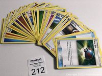 Front sides of 30 assorted Pokémon trading cards fanned out showing variety of types and Trainer cards e.g. Great Ball