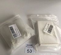 Two sealed kits, one containing massage suction bottles and another with crystal Guasha boards, placed on a white surface with auction tag.