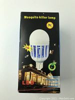 Box packaging showing the LED mosquito killer lamp image and promotional text. Lamp has a white bulb shape with blue grid and mosquito killing function.