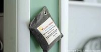 Single Yellow Robin air purifying bag hanging on white door handle
