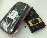 Black Nintendo Switch protective case in plastic wrap alongside boxed tempered glass screen protector