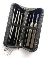 Open black zippered case containing 8 stainless steel blackhead remover and pimple extractor tools arranged with metal loops and lancet needles visible.