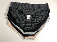 Six folded briefs in various colors and patterns, black striped at top, showing size XL tag