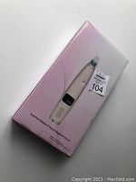 Box showing image of white home-use acne pore cleaner device with digital display and buttons.