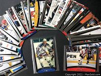 Thirty Upper Deck hockey player cards spread in a semi-circle on black surface, showing action images and team colors