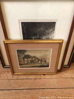 Group of framed artworks stacked showing a horse and rider scene with a gold frame