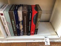 Full view of seven CD box sets on a shelf showing titles and condition.