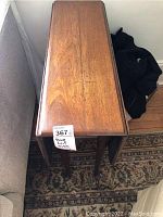 Top view of the closed drop leaf table showing wood grain and surface condition.