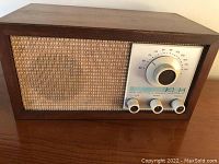 Photo showing the full front view of the KLH Model Twenty One radio with wooden cabinet and cloth speaker grille.