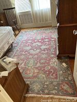 Rug displayed on wooden floor in room with furniture; shows full length and floral pattern.