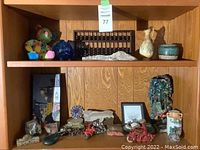 Overall view of top two shelves showing abacus, vases, glass jar and large ceramic sculpture