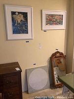 Two framed cloisonné art pieces and a vintage wooden framed mirror next to a 24x24 abstract painting leaning against the wall, showing lot arrangement.