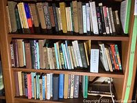 Three bookshelves filled with mixed hardcover and paperback books