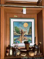 Overall view of lot showing framed cloisonné artwork and assorted decor on wooden shelving