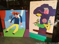 Two paintings displayed side by side showing overall size, style, and color palette