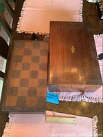 Closed chessboard box beside closed writing desk box on table