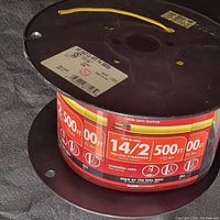 Photo of full spool of speaker wire with visible label showing specifications including 14/2 gauge, 500 feet length, yellow stranded wire for in-wall use.