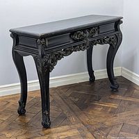 Side angle view of an Antique Venetian Baroque style console table showing curved legs and ornate carvings with a dark finish.