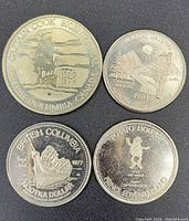 Top view of all four coins arranged in a square on a black background showing front designs and inscriptions.