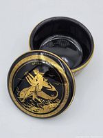 Open top view showing inside of the black porcelain container and detailed gold design on the lid.