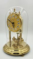 Full front view of the vintage Bulova anniversary clock with gold-tone metal and glass dome