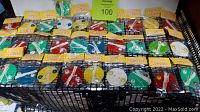 Display of 31 assorted vintage Whistling Whizzer toys in original sealing packaging in various colors including green, red, blue, yellow, and white arranged on a black shelf.