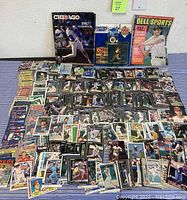 Full lot arranged on floor showing assorted baseball cards spread out, Chicago Cubs yearbook, Starting Line-Up action figure, Dodger Medallion pin and Dell Sports Magazine