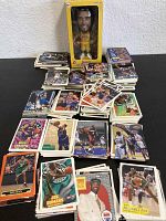 Photo showing multiple NBA trading cards spread out, depicting players in action and portraits from different teams and years, laid out on a table.