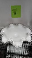 Top view of white milk glass candy dish showing ruffled curly edge and smooth interior surface.