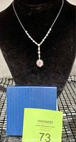 Full necklace displayed on black velvet bust with original blue striped gift box beneath.