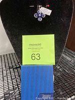 Pendant displayed on a black velvet stand with original blue gift box below.