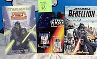 Photo showing all three items: Knights of the Old Republic graphic novel, sealed Kenner R2-D2 action figure, and Star Wars Rebellion graphic novel.